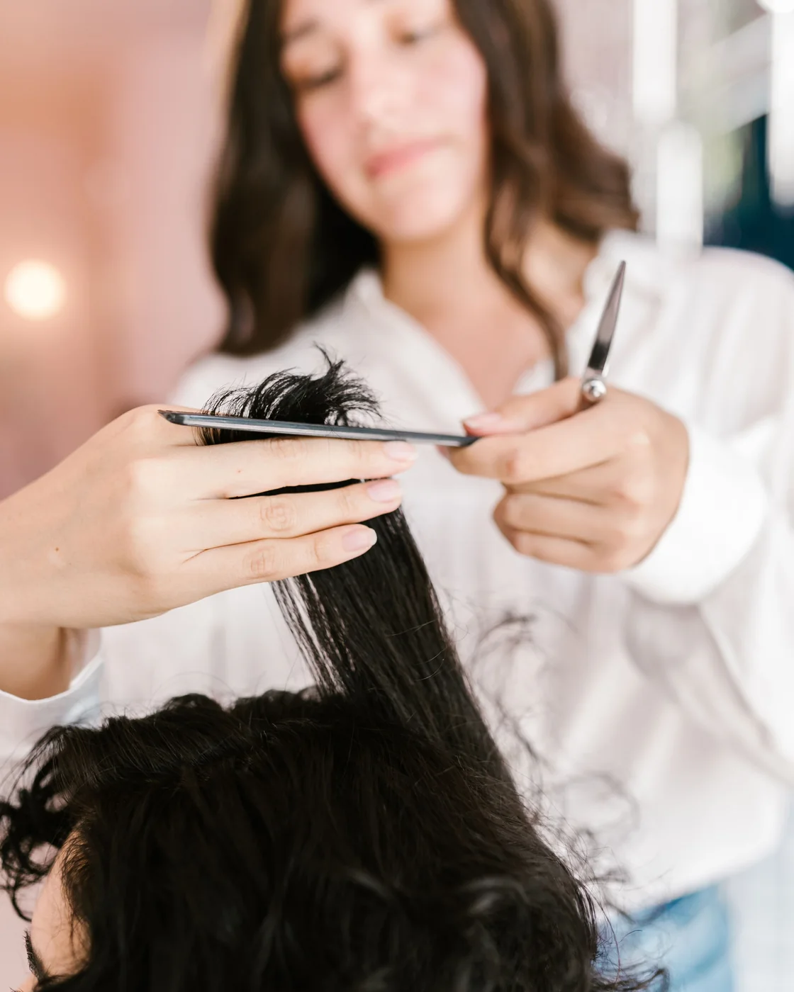 Kapper knipt donker haar met een schaar en kam